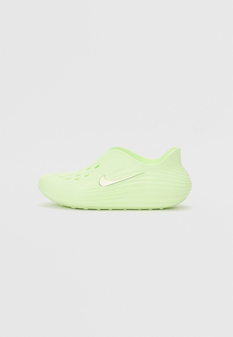 Zoccoli verde chiaro con una superficie liscia e strutturata, fori di ventilazione laterali e un logo Swoosh bianco della Nike sul lato esterno.