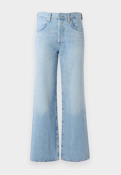 Jeans a zampa d'elefante in denim blu chiaro con vita alta, cinque tasche e una leggera sbiaditura vicino all'orlo. Presentano una vita standard e chiusura con bottone.