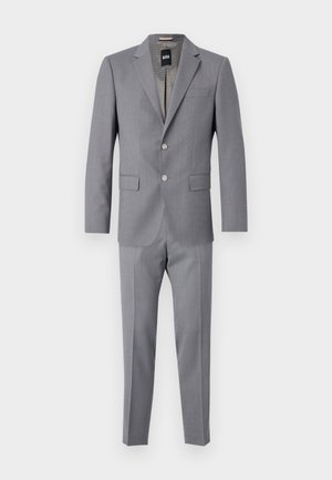 Costume gris en tissu texturé, avec une coupe ajustée, fermeture à deux boutons, poche poitrine et pantalon slim.