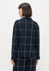 Ναυτικό μπλε και πράσινο καρό πουκάμισο με απαλή υφή, μακριά μανίκια, γιακά και ευθύ κόψιμο, απεικονιζόμενο από πίσω.