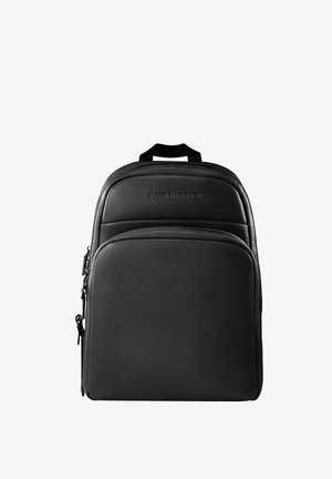 Mochila de cuero negro con una textura suave, que cuenta con un asa superior, dos compartimentos con cremallera y un logo embossado en la parte frontal.
