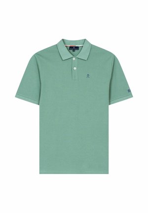 Polo verde de manga corta con dos botones blancos, pequeño logo azul en el pecho y texto "H&N" en la manga izquierda.