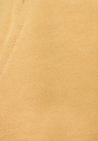 Light yellow knitted fabric with fine texture and visible stitching. Features soft, elastic material; no discernible patterns or accents.