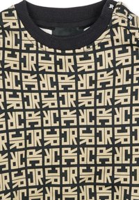 Maglietta a maniche corte nera con girocollo, caratterizzata da un motivo ripetuto di logo "JR" in beige; colletto e spalle a costine. Tessuto morbido, design casual.