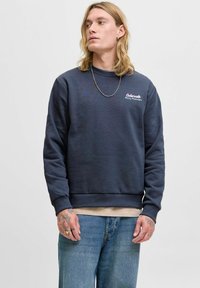 Sudadera de cuello redondo en azul marino de tejido suave, con puños y dobladillo de canalé, que presenta un bordado blanco que dice "Colorado Rocks Mountains" en el pecho.