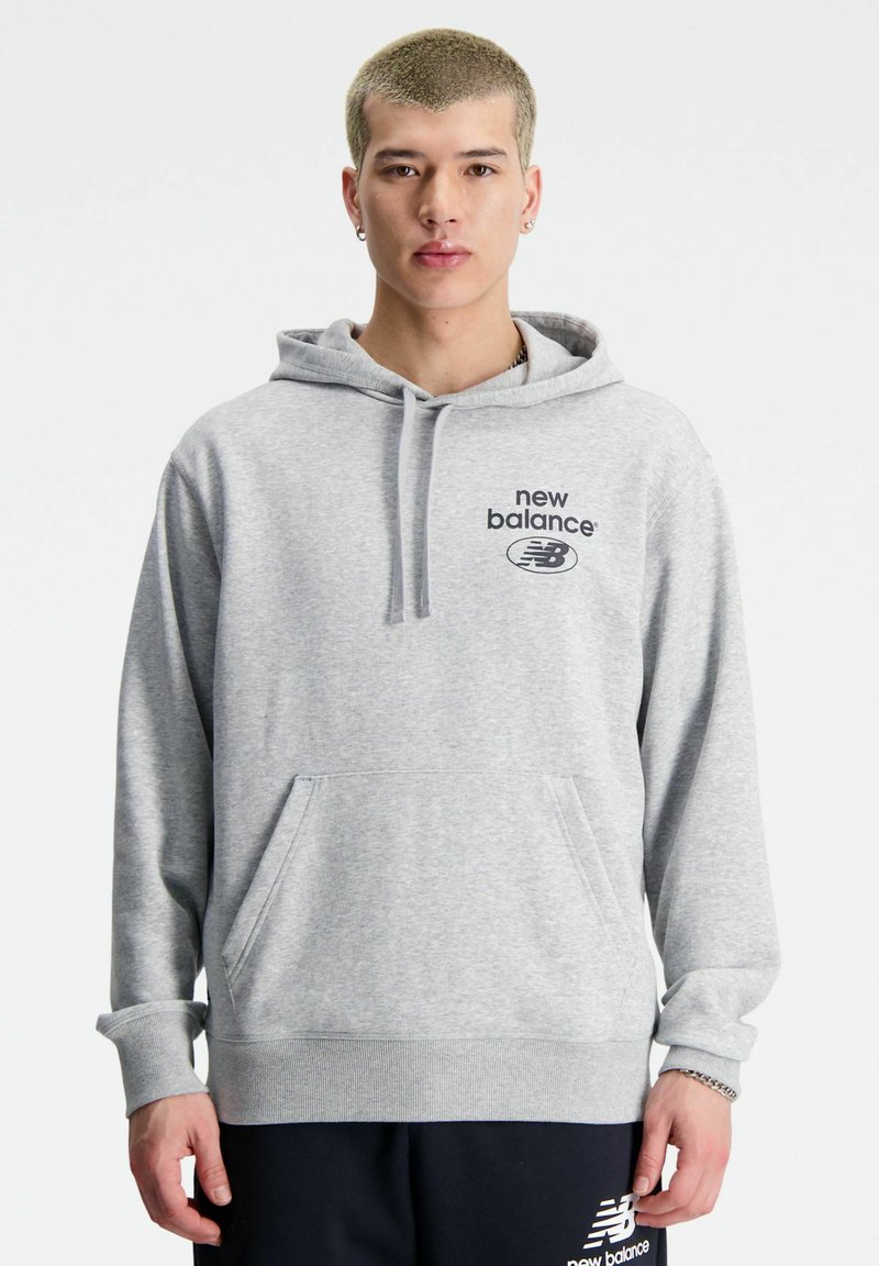 Szara bluza z kapturem z kieszenią z przodu, sznurkiem do ściągania i logo "new balance". Posiada ściągacze na rękawach i dole oraz wykonana jest z miękkiego materiału bawełnianego.