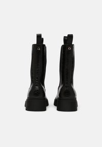 Black faux leather ankle boots with a glossy crocodile texture, square toe, and thick rubber sole. Features pull tabs for easy wear.