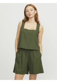 Top de lino verde con escote cuadrado y pantalones cortos, con un corte relajado y bolsillos laterales, que muestra una textura suave.