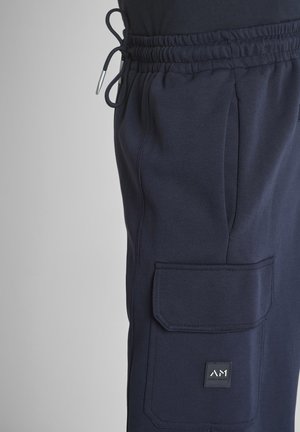 Donkerblauwe sweatpants met elastische tailleband, trekkoord en klepzak met een klein vierkant merklogo.