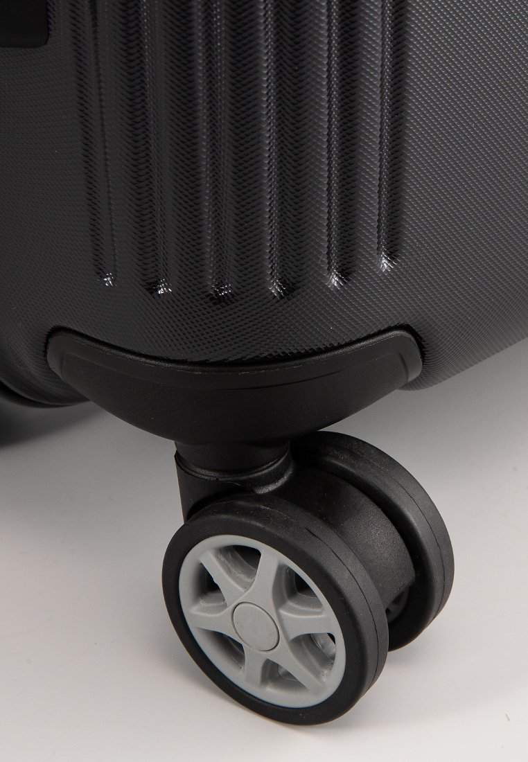 Black hard-shell suitcase with ribbed texture, featuring two black wheels with gray accents, and a smooth plastic handle for easy maneuvering.