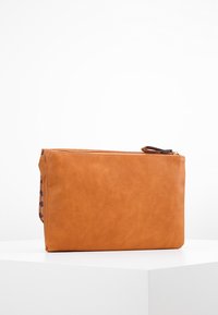 Brun læderpung med tekstureret finish, rektangulær form, top lynlås lukning og farverigt blomsterprint på siden.