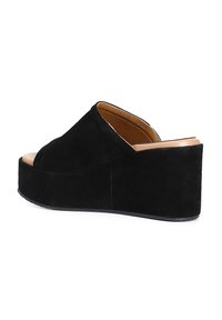 Sandalo platform in suede nero con punta aperta e suola spessa. Presenta una fodera in pelle liscia e un design minimalista.