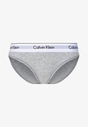 Graue Baumwollbikini-Unterwäsche mit einem weißen Bund, auf dem das schwarze Logo "Calvin Klein" prangt. Glatte Textur, Standard-Schnittdesign.