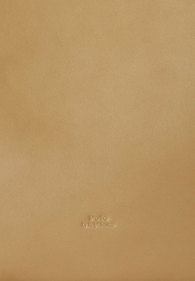 Bež usnjeni material z gladko teksturo. Na sredini je vtisnjen napis »Polo by Ralph Lauren«. Preprost, minimalističen dizajn.