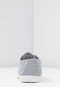 Scarpa slip-on a righe in tela blu e bianca con suola in gomma bianca. Tallone pieghevole per una facile indossatura; fodera interna decorata.