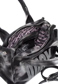Borsa a mano nera in tessuto con superficie testurizzata, dotata di accessori in argento e di un interno a motivo rosa con tasche con zip e aperte.