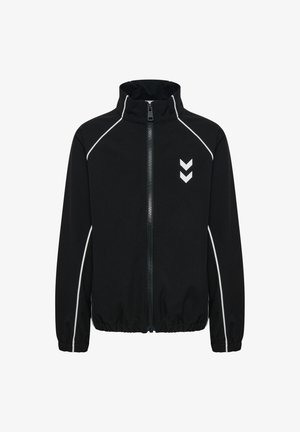 Zwarte trainingsjas met ritssluiting, witte bies op mouwen en schouders, elastische manchetten en zoom, en twee witte pijlen naar beneden op de borst.