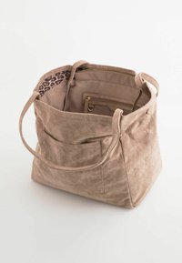 Beige mocka axelväska med två handtag, med ett foder i leopardmönster, inre fickor och en framficka för förvaring.