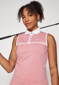 Rosa ermeløs polo-skjorte med hvit krage og knappestolpe, med subtile striper over brystet og Calvin Klein-merke.