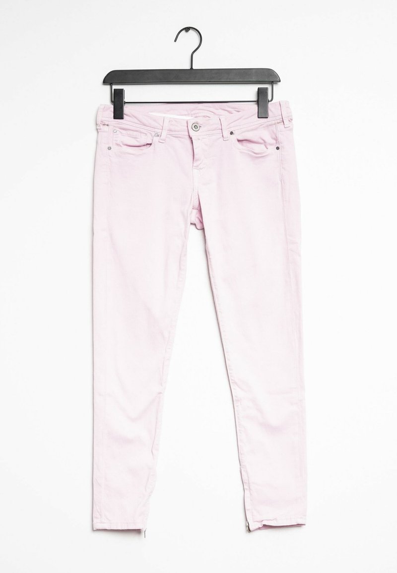 Jeans skinny de algodón rosa exhibidos en una percha negra, que cuentan con bolsillos frontales, cremallera y un ajuste ajustado con costuras en contraste.