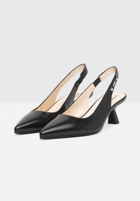 Scarpe slingback in pelle nera con punta appuntita, tacco a blocco basso e lati con intagli impreziositi da dettagli in metallo argentato.