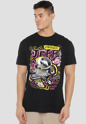 Black cotton t-shirt featuring a colorful graphic print of a shark with "JEFF THE LANDSHARK" text, surrounded by doodles and bright accents.