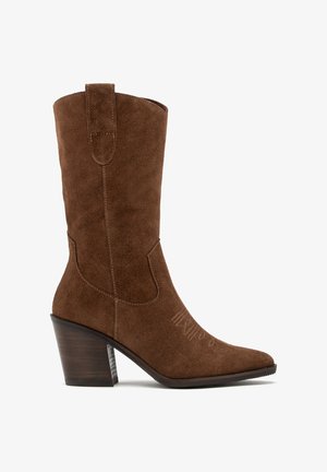 Brązowe zamszowe kowbojki z wydłużonym noskiem,haftowanymi detalami i niskim, drewnianym obcasem. Posiadają pętelkę ułatwiającą zakładanie.