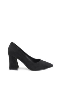 Scarpa con tacco alto in suede nero, con punta affusolata e tacco a blocco spesso. Texture liscia con un design minimalista. Ritagli circolari sui lati.