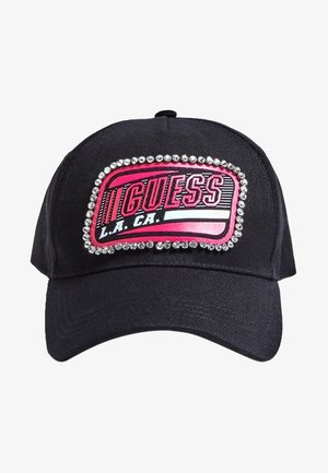 Gorra de béisbol negra con un parche rosa y negro que dice "GUESS L.A. CA." en el panel frontal, bordeado por una fila de brillantes transparentes.
