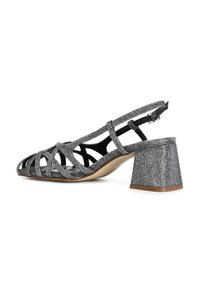 Slingback obuv v černé a stříbrné barvě, s otevřenou špičkou, zkříženými pásky a texturovaným blokovým podpatkem. Plná podešev s jemným zakřivením.