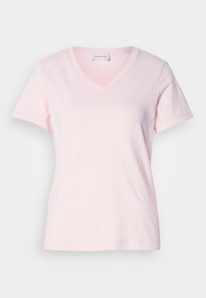 Heledad roosa Calvin Klein Jeans lühikeste varrukatega V-kaelusega T-särk, mille vasakul rinnaosal on väike brodeeritud "CK" logo.
