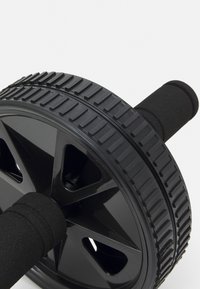 Rouleau ab en forme de roue avec un pneu en caoutchouc noir, des poignées texturées et un noyau en plastique dur. Dispose d'un design à cinq rayons.