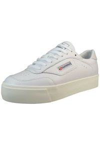 White leather sneaker with a textured rubber sole. Features a stitched logo patch and laces. Rounded toe and low-profile design.