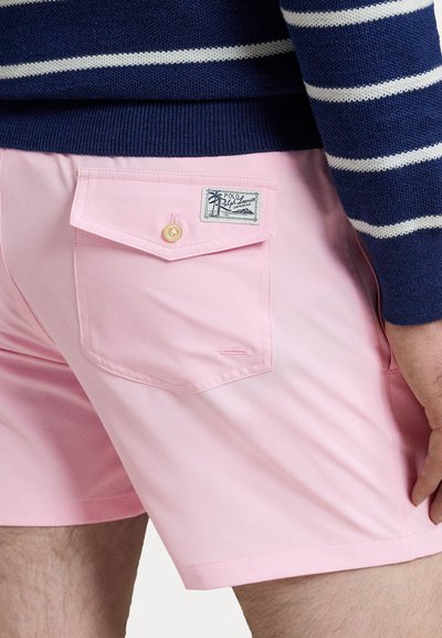 Shorts de baie roz cu un buzunar la spate dotat cu închidere prin buton și o etichetă cu marcă, textură netedă și un design ajustat.