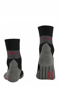 Calze nere e grigie con design rigato, dotate di punta e tallone rinforzati, e il marchio "FALKE" in rosso sul polsino.