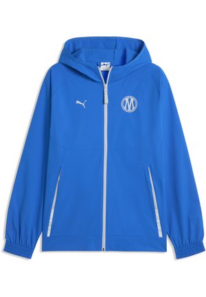 Veste à capuche bleue avec fermeture éclair blanche sur toute la longueur, poignets élastiques, deux poches zippées, logo Puma et emblème circulaire sur la poitrine.