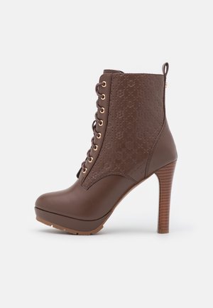 Bottine marron à talons hauts avec lacets à l'avant, motif floral embossé sur la tige et talon empilé en bois.