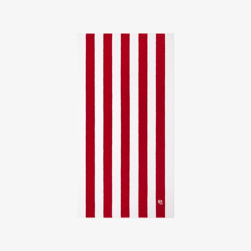 Πετσέτα με κόκκινες και λευκές ρίγες εναλλασσόμενες με φαρδιές ρίγες, κατασκευασμένη από πετσέτα βελουτέ, με ένα μικρό λογότυπο στη δεξιά κάτω γωνία.