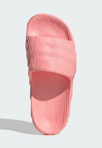 Pinkfarbene Sandale mit gerippter Textur und breitem Riemen. Verfügt über eine offene Zehenpartie und eine strukturierte Oberfläche für besseren Halt. Hergestellt aus leichtem Material.