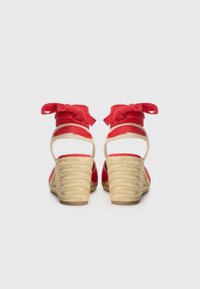 Röda espadrillosandaler med ankelsnören, vävd jutekil, öppen bakdesign och en slät kanvasöverkant.