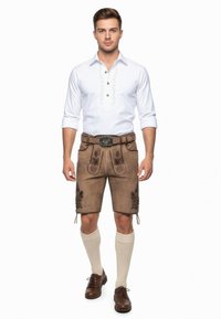 Traditionele Duitse lederhosen van bruin leer met bloemenborduring, gecombineerd met een witte shirt met knoopsluiting en een riem.
