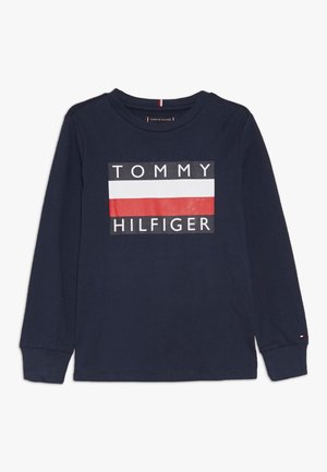 Marineblaues Langarm-T-Shirt aus Baumwolle, mit einem weißen und roten Rechteck-Logo in der Mitte, das den Text "TOMMY HILFIGER" zeigt.
