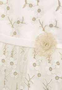 Weißes Kleid mit floraler Stickerei und goldenen Akzenten. Enthält ein Stoffblumendetail an der Taille. Texturierter Tüllrock sorgt für Tiefe.