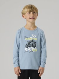 Αγόρι με ξανθά μαλλιά που φοράει μπλε ανοιχτό μακρυμάνικο μπλουζάκι με μοτοσικλέτα και το κείμενο «Street Racer New York 23».