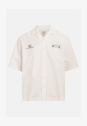 Weißes Kurzarm-Hemd mit Knöpfen und Kragen, mit Textlogos „Revolutionary Pressure" auf der linken Brust und „Redefined Rebel Street Apparel" auf der rechten Brust.