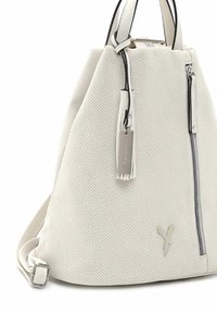 Bolso blanco perforado con una forma estructurada, acentos negros en contraste, herrajes plateados, cierre de cremallera y una etiqueta desmontable.