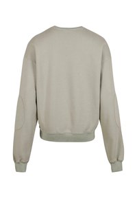 Lys grå cropped sweatshirt med lange ermer, rund hals og ribbede mansjetter. Har albueplaster og en myk tekstur.