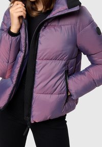Pufferjakke i iriserende lilla med lynlåslukning, sidelommer, elastiske manchetter og tekstureret stof med vandrette quiltede linjer.
