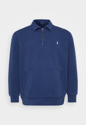 Sudadera de media cremallera en azul marino, confeccionada con una mezcla de algodón. Cuenta con un bolsillo frontal y un pequeño logo bordado en el pecho. Textura suave.