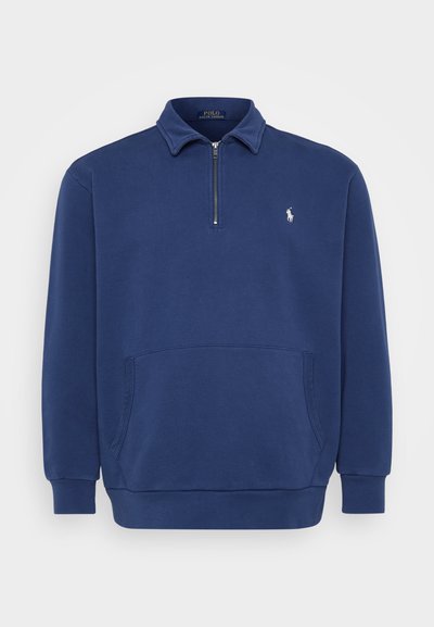 Sudadera de media cremallera en azul marino, confeccionada con una mezcla de algodón. Cuenta con un bolsillo frontal y un pequeño logo bordado en el pecho. Textura suave.